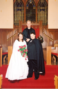Marjorie, Arnie, and their minister pose for a photo at the wedding.